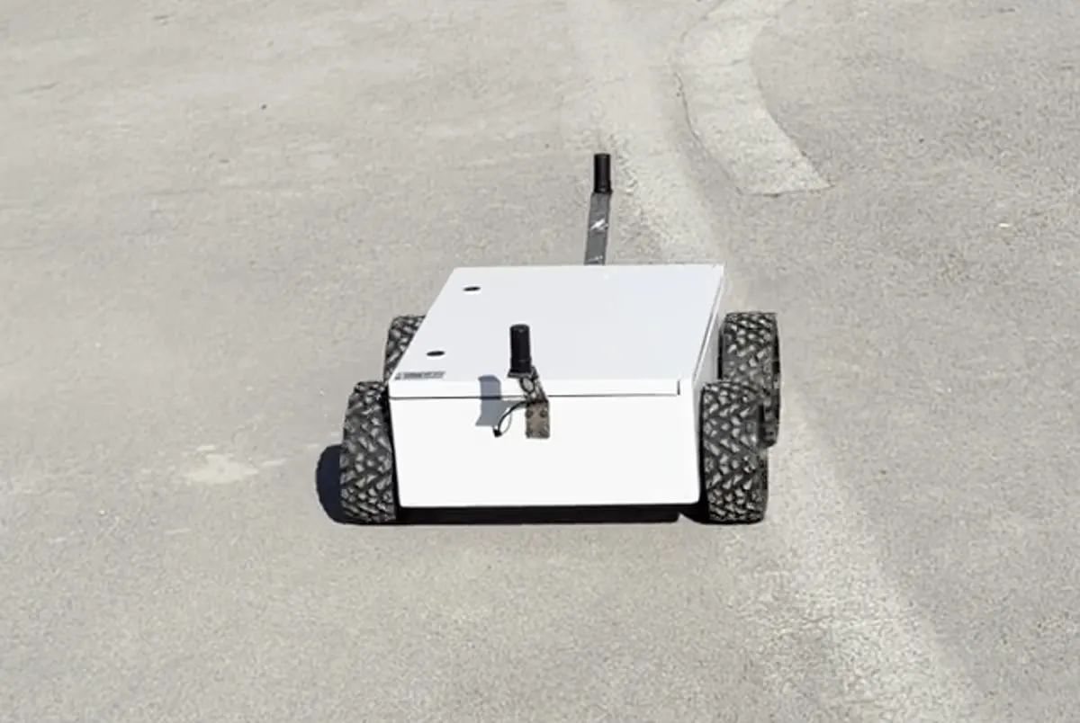 The 4x4 rover outdoors on a paved surface, with both GNSS antennas visible on its mast.